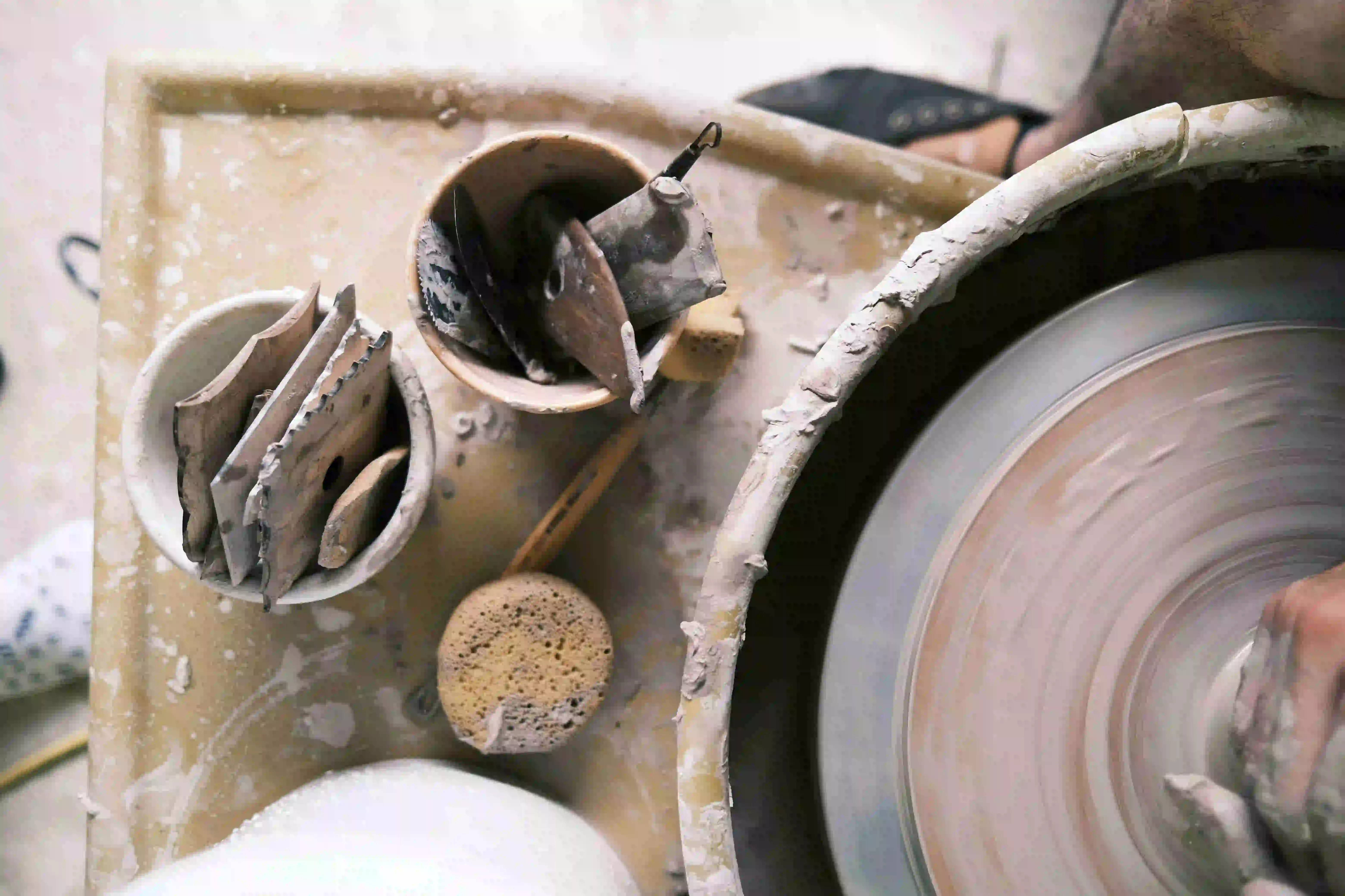 Artisan potter shaping clay on pottery wheel in Studio Cacino studio